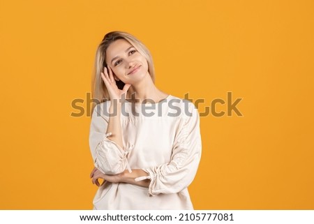 Dreaming look. One beautiful caucasian girl posing isolated over yellow background. Model in casual clothes. Youth culture. Natural beauty. Concept of human emotions, facial expression, beauty, ad