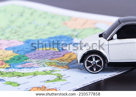 Close up view of toy car for travel concept on colorful map.