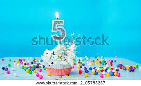 Beautiful congratulations on the birthday of a five-year-old child on a blue background, a card for 5 years happy birthday copy space. Festive background with cream cake