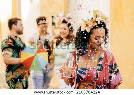 Brazilian Carnival. Woman drinking water during carnival block on the street Royalty-Free Stock Photo #2105784224