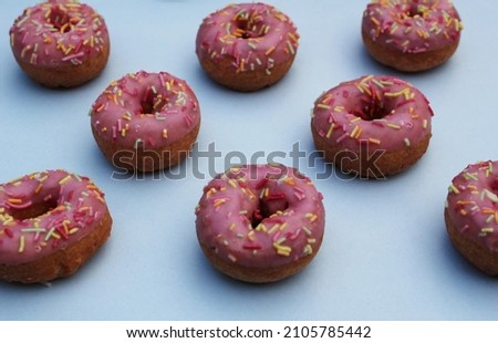 donut donuts sprinkles on doughnuts pink bright glazed frosting sugar strands on blue turquoise background 100s and thousands decoration pattern