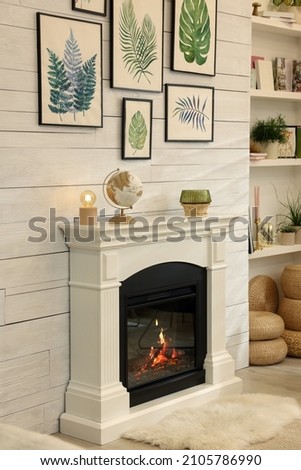 Stylish room interior with beautiful floral pictures and decorative fireplace