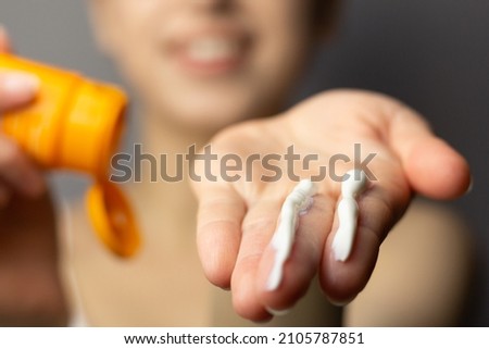 Young woman applying the correct amount of sunscreen for face and neck. Royalty-Free Stock Photo #2105787851