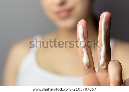 Young woman applying the correct amount of sunscreen for face and neck. Royalty-Free Stock Photo #2105787857