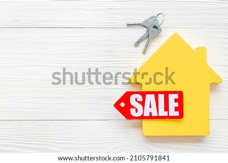 House for sale - sale tag with wooden house figure