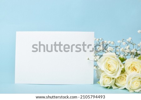 A sheet of paper with white bush roses on a blue background. Banner with a sheet of crumpled paper texture with an empty space. copy space
