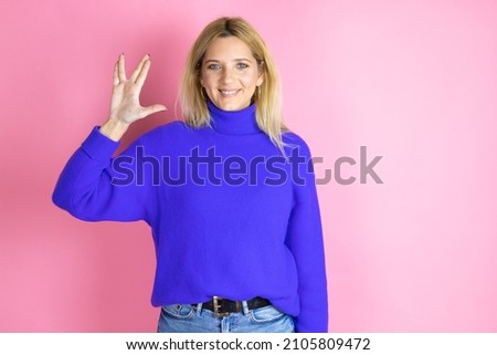 Young beautiful woman wearing casual sweater over isolated pink background doing hand symbol