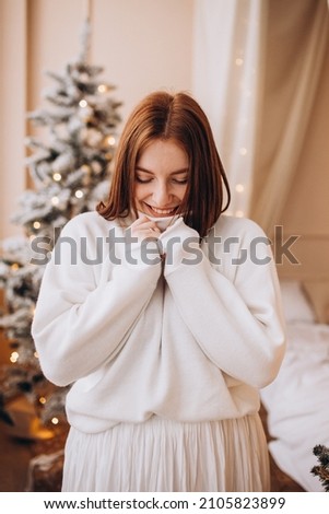 girl with red hair on the background of the Christmas tree in anticipation of Christmas