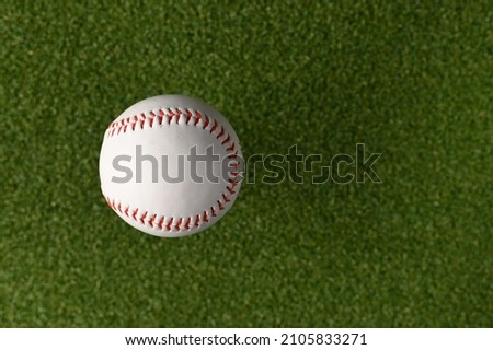 White baseball ball on a green sports field. Minimalism. There are no people in the photo. Abstraction. Professional and amateur sports, sports games, outdoor activities, training.