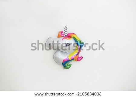 A inflatable unicorn hanging on the wall for birthday decoration