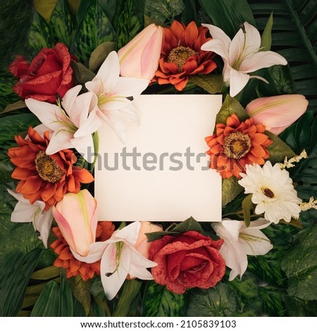 Spring wreath made of colorful flowers and leaves. Natural round frame layout with paper card. Flat lay.