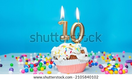 Beautiful birthday greetings to a ten-year-old child on a blue background, card for 10 years happy birthday copy space. Festive background with cream cake. Royalty-Free Stock Photo #2105840102