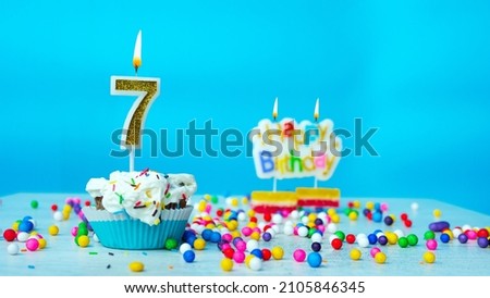 Beautiful birthday greetings to a seven-year-old child on a blue background, postcard for 7 years happy birthday copy space. Festive background with cream cake