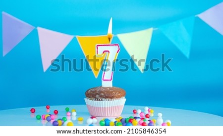 Beautiful birthday greetings to a seven year old child on a blue background, a card with the number 7 years happy birthday copy space. Background with festive children's decorations