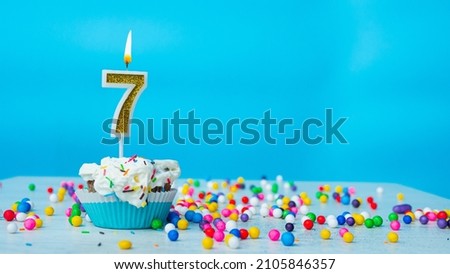 Beautiful birthday greetings to a seven-year-old child on a blue background, card for 7 years happy birthday copy space. Festive background for children with cream cupcake