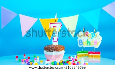 Beautiful birthday greetings to a seven year old child on a blue background, a card with the number 7 years happy birthday copy space. Background with festive decorations