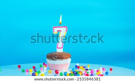 Beautiful birthday greetings to a seven year old child on a blue background, a card with the number 7 years happy birthday copy space. Festive children's background with cream cake.