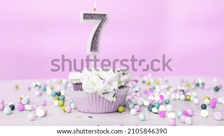 Beautiful birthday greetings to a seven year old child on a pastel pink background, card for 7 years happy birthday copy space. Festive children's background with cream cake Royalty-Free Stock Photo #2105846390