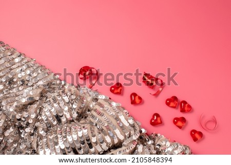 Pink Valentine's Day background with hearts and shiny, glittering fabric with sequins. Free space for text, copy space. Postcard, greeting card design. Love, celebration concept.