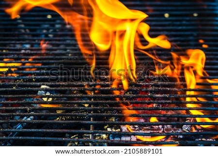 Empty hot charcoal barbecue grill with bright flame. Hot burning grill, outdoors cooking food