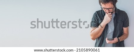 Casual man using smart mobile phone for communication, panoramic image with selective focus