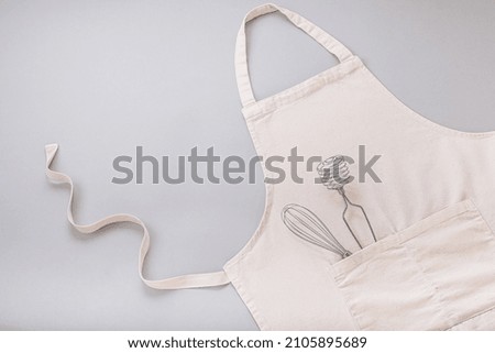 Apron and utensils baking desserts on a gray background. flat lay, top view. High quality photo
