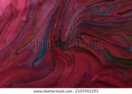 Beautiful shimmer stains of liquid nail polish.Red,green and blue colors.Stripy paint texture.Nail lacquer flow background in fluid art technique.Minimalism concept.Copy space,horizontal photography.