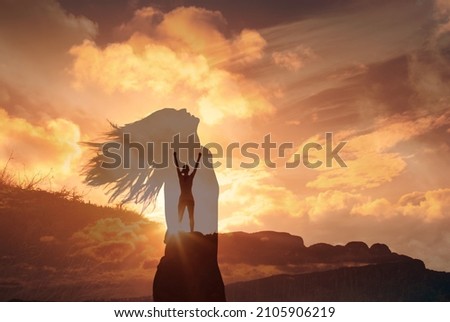 Strong woman on a mountain letting go of fears feeling free and alive  Royalty-Free Stock Photo #2105906219