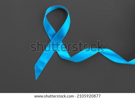 Blue ribbon on black background prostate cancer awareness concept