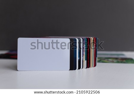 Blank white plastic card close-up in foreground in a row of other plastic customer loyalty cards on blurred gray and white background Royalty-Free Stock Photo #2105922506