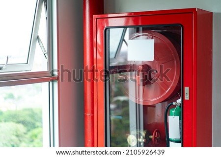 Cabinets of fire protection set is settled with the Emergency Fire Extinguisher and Rolled Pipe