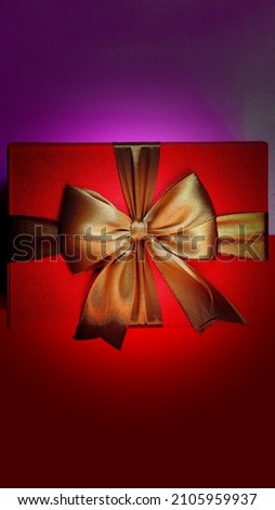 An elegant and neatly arranged red gift box on a black background. New year and christmas concept. Valentine gift concept. Top View. High angle view. Vertical Photo