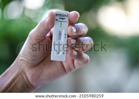 Negative test result with SARS CoV-2 Rapid antigen test kit (ATK) in her hand on nature background , Covid-19 infectious protective concept Royalty-Free Stock Photo #2105980259