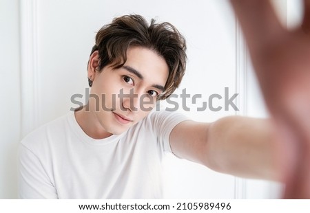 Portrait of young handsome asian man use smartphone selfie say hi over white background. Happy asian guy online influencer blogger. Education technology connected people man lifestyle concept Royalty-Free Stock Photo #2105989496