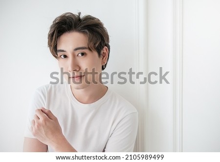 Attractive young handsome smiling face positive asian, korean happy casual man, stay home minimal lifestyle. Closeup portrait of asia middle age 20s man wearing white shirt in studio. Young model boy  Royalty-Free Stock Photo #2105989499