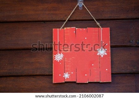 A blank red wood sign hanging on antique rustic wooden background. Holiday background with copy space