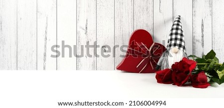 Background, backdrop, banner. Valentine's Day farmhouse theme SVG craft product mockup styled with red roses, heart shaped gift, and buffalo plaid gnome against a white wood background.