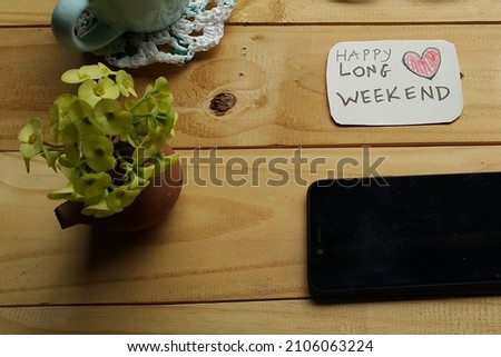 Happy long weekend text on wooden table. Selective focus.