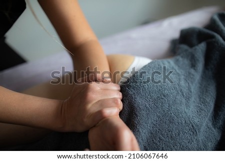 A female masseur does an anti-cellulite wellness massage. Close-up.