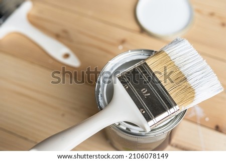 Top view on white paint brush on the opened can on the wooden table or floor painting and renovation repairing concept Royalty-Free Stock Photo #2106078149