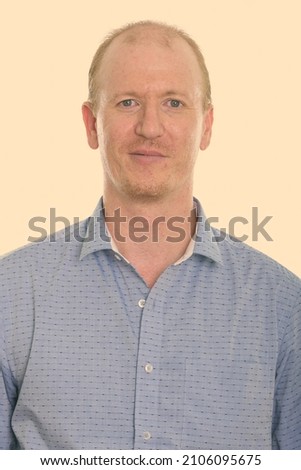 Studio portrait of balding man with short hair against plain studio background