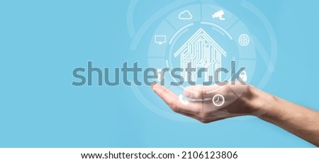 Hand hold house icon.Smart home controlled, intelligent house, and home automation app concept.Pcb design and person with smart phone. Innovation technology internet Network Concept Royalty-Free Stock Photo #2106123806