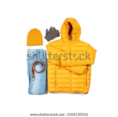 Stylish winter down jacket, jeans, hat, belt and gloves on white background