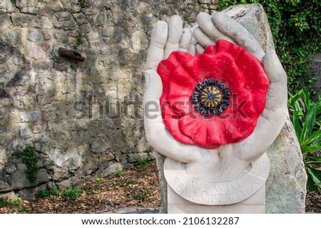 Red poppy wreaths laid at the bottom of a war memorial for Remem