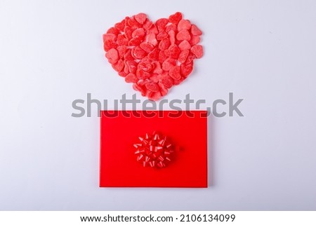 Red heart shape candies over gift box around copy space on white background. love and valentine, gift and sweets.