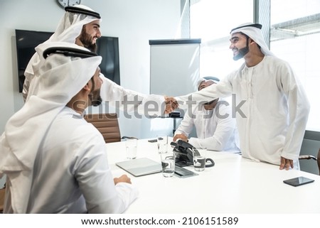 Group of business managers from the emirates meeting and working together in Dubai. Arabian businessmen wearing traditional clothes Royalty-Free Stock Photo #2106151589