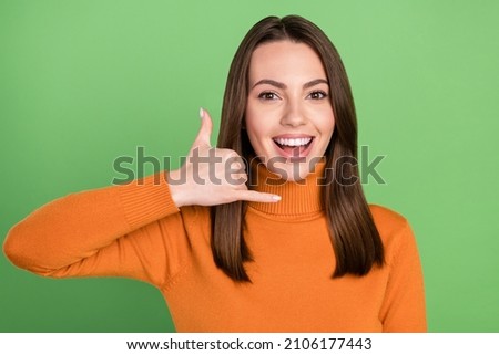 Photo portrait woman smiling showing call me sign isolated pastel green color background