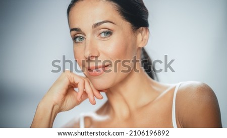 Beautiful Caucasian Woman Touches Her Perfect Face, Smiling. Female Enjoying Her Beauty, High Self Esteem, Wellness. Natural Cosmetic Skincare Products. Medium Portrait with Isolated Background