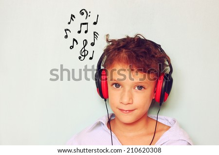 little kid with headphones  listening to music and notes sketches 
