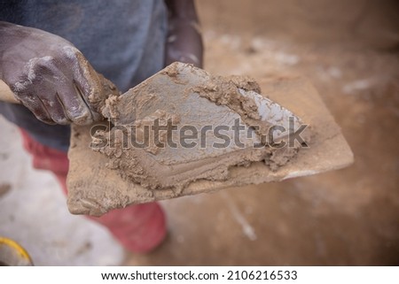 Lusaka, Kaunda Square, Zambia, 20,09,2021.., African Builder plastering a house . Normal African works, African man Working with his hands  Royalty-Free Stock Photo #2106216533